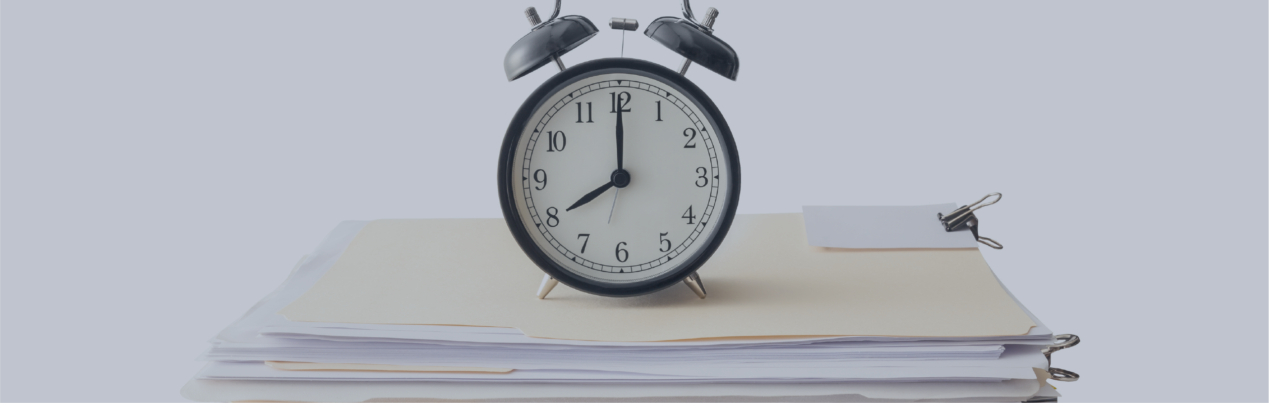 A clock sitting on top of a pile of files.