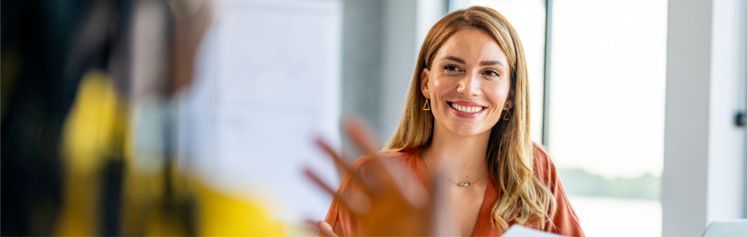 Happy businesswomen speaking to coworker